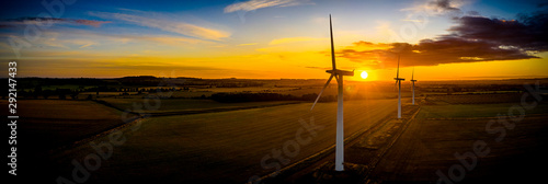 Fotomural Aerial of wind turbines at sunrise in the English countryside with a dramatic sk