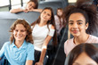 © Viktoriia - Classmates going to school by bus sitting smiling happy blurred background