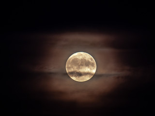 a closeup view of the micro harvest full moon with partial cloud cover and halo on friday the 13th a