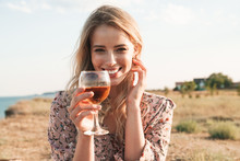 Photo Of Happy Blonde Woman Holding Wine Glass And Smiling