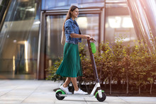 Carefree Young Woman Riding An Electric Scooter