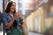 © pikselstock - Young woman with smartphone in an urban city area