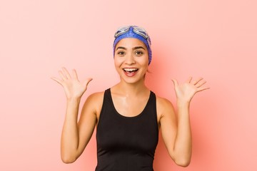 Young arab swimmer woman isolated celebrating a victory or success, he is surprised and shocked.