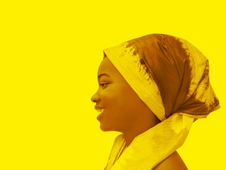 Profile view of a beautiful girl wearing a headscarf, yellow background