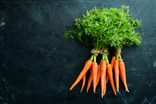Fresh Carrots On A Black Stone Background. Top View. Free Space For Your Text.