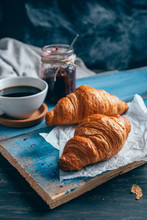 Delicious Croissants With Jam And Coffee On Dark Wooden Table