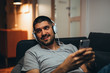 © cherryandbees - close up of handsome young man relaxed on sofa at his home listening music on headphones
