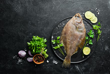 Raw Flounder Fish With Spices. Seafood On A Black Stone Background. Top View. Free Copy Space.