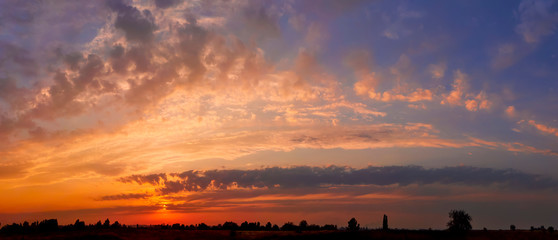 Wall Mural - bright sunlight through the clouds against a breathtaking evening sky at sunset. panorama, natural c