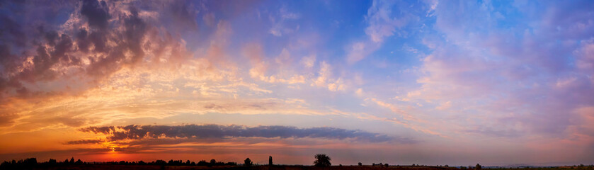 Wall Mural - bright sunlight through the clouds against a breathtaking evening sky at sunset. panorama, natural c