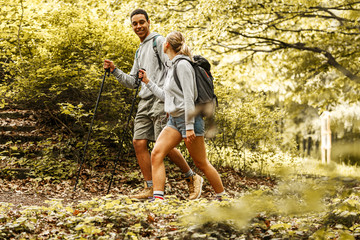 Wall Mural - young couple hiking in nature.they enjoying in walk and fresh air.