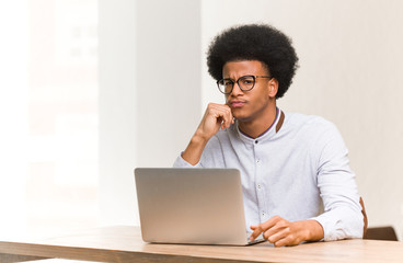 Wall Mural - Young black man using his laptop crossing arms relaxed