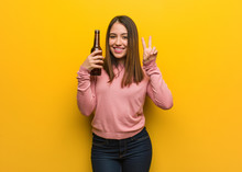 Young Cute Woman Holding A Beer Showing Number Two