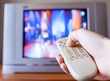 © kieferpix - Hand pushing tv remote control