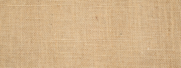 Wall Mural - Cotton woven fabric background with flecks of varying colors of beige and brown. with copy space. office desk concept / Hessian sackcloth burlap woven texture background