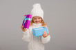 © КРИСТИНА Игумнова - little blonde girl in winter white winter hat smiling holding a pink gift box