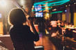 © Евгений Вершинин - Young woman singing in karaoke and holding a microphone close-up. Singer at a party or concert on the background of a luminous star and smoke.