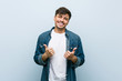 © Asier - Young hispanic cool man raising both thumbs up, smiling and confident.
