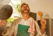 © TheVisualsYouNeed - dramatic grunge portrait of  house husband or single man in kitchen apron doing domestic chores washing dishes or cooking in stress screaming frustrated and desperate