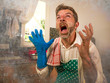 © TheVisualsYouNeed - dramatic grunge portrait of  house husband or single man in kitchen apron doing domestic chores washing dishes or cooking in stress screaming frustrated and desperate