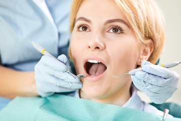 Wall Mural - Dentist checks the teeth of a girl