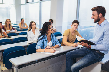 Wall Mural - Young students listening to professor in the classroom on college