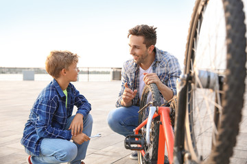 Wall Mural - Father and his son repairing bicycle outdoors