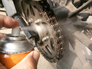 Motorcycle maintenance chain using oil spray