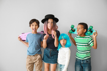 Wall Mural - Grimacing little children with skateboards on light background