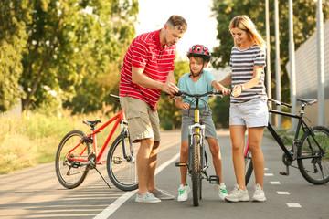 Sticker - Parents teaching their son to ride bicycle outdoors