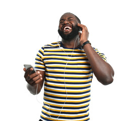 Wall Mural - Happy African-American man listening to music on white background
