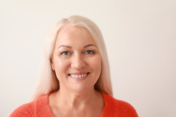 Poster - Portrait of beautiful mature woman on light background