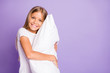 © deagreez - Portrait of positive cheerful sweet kid hug her big soft pillow enjoy weekends free time feel content have bed time wear white sleep-wear isolated over violet color background