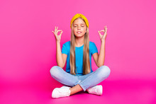 Full Length Photo Of Funky Peaceful Calm Kid Sit With Her Legs Crossed Practice Yoga Meditate Om Wear Blue Denim Jeans Sneakers Isolated Over Pink Color Background