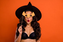 Trick Or Treat Halloween Concept Photo Of Beautiful Nude Brunette Charming Lady Holding Bat Shaped Wooden Stick See Handsome Wizard Guy At Party Wear Black Witch Cap Isolated Orange Background