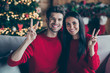 © deagreez - Portrait of charming two married romantic people make v-signs celebrate newyear x-mas sitting on divan indoors in house