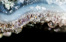 Gemstone Amethyst Closeup As A Part Of Cluster Geode Filled With Rock Quartz Crystals.