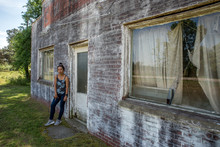 Woman Standing In Front Of Dilapidated And Abondoned Restaurant  In Virginia