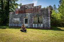 Asian Woman Sitting In Front Of Dilapidated And Abondoned Restaurant  In Virginia