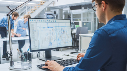 Poster - Over the Shoulder Shot of Engineer Working with CAD Software on Desktop Computer, Screen Shows Technical Drafts and Drawings. In the Background Engineering Facility Specialising on Industrial Design