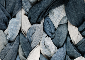 textured background of a variety of denim and pants in various shades of blue intertwined in braids