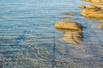 Wall Mural - simple natural background picture of peaceful shallow water shore line with stones