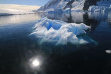 Fototapeta  - wystający ponad taflę wody wierzchołek góry lodowej przy wybrzeżu antarktydy w słoneczny dzień