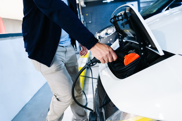 A man recharging an electric car