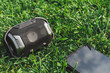 © madrolly - Top view of small black portable speaker in the grass