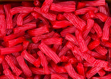 Heap Of Red Strawberry Licorice Twizzlers Red Vine Candies At Supermarket. Creative Sweet Food Confectionery Pattern. Kids Treats Birthday Party Sugar Addiction Unhealthy Diet Concept