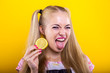 Naughty blonde with lemon slice makes a sour face facial expression isolated against yellow background