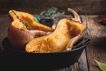 Wall Mural - Baked pumpkins with thyme in cast iron skillet