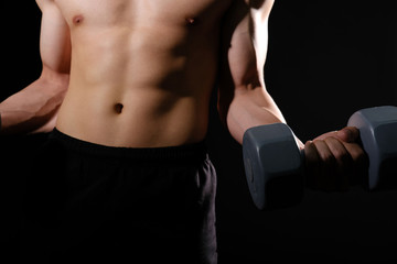 athletic muscular bodybuilder man with naked torso six pack abs working out with dumbbell. fitness  exercise concept