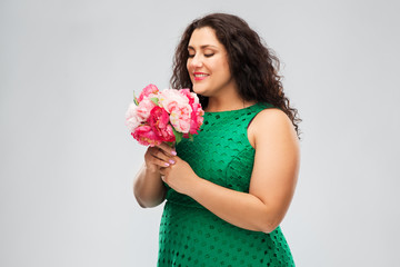 Wall Mural - people and portrait concept - happy woman in green dress with flower bunch over grey background